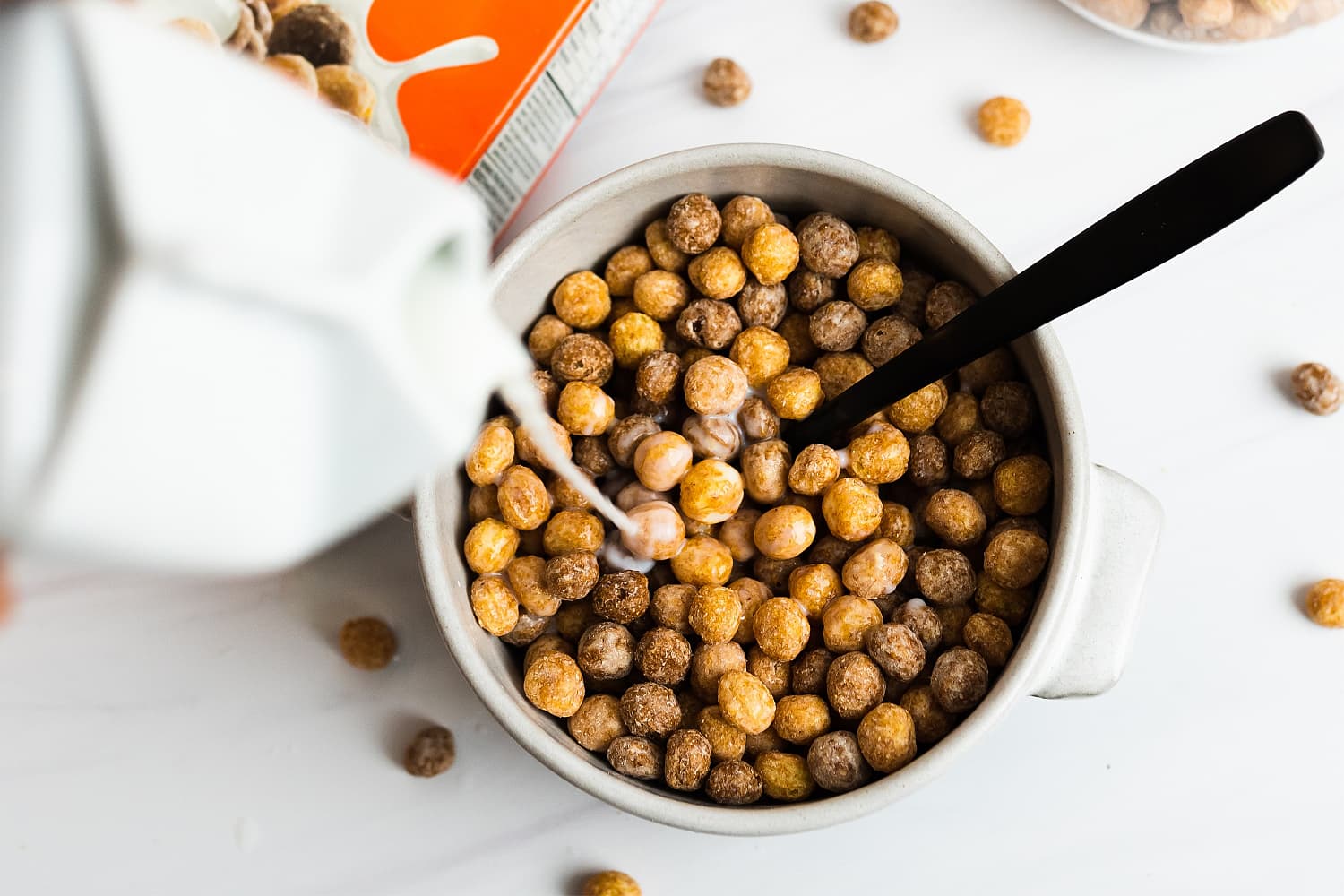 Bowl of Reeses Puffs getting milk poured on them